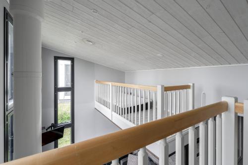 a white staircase in a house with a wooden ceiling at Peaceful 2BR Getaway Cabin at the Top of Riihivuori in Muurame