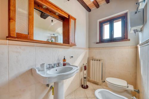 a bathroom with a sink and a toilet and a mirror at Casale Rialto in Montefalco