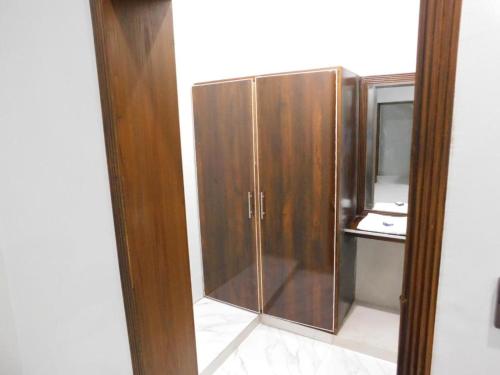a wooden cabinet in a room with a mirror at Airport view hotel in Lahore