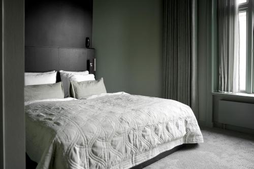 a bedroom with a white bed and a window at Hotel Hans in Copenhagen
