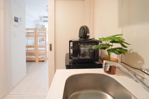 a kitchen with a sink and a microwave at Encounter Ohori403 in Fukuoka
