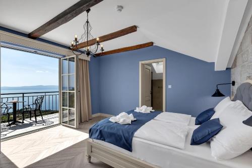 a blue bedroom with a bed and a balcony at Hotel Liberan - Nature's Retreat in Podgora