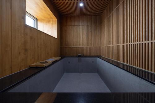 an empty swimming pool in a wooden room with a window at Aank Ryokan Hotel Ansan Seonbu Branch in Ansan
