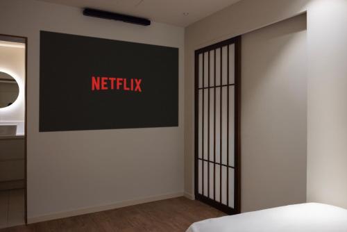 a hotel room with a netflix sign on the wall at Aank Ryokan Hotel Ansan Seonbu Branch in Ansan