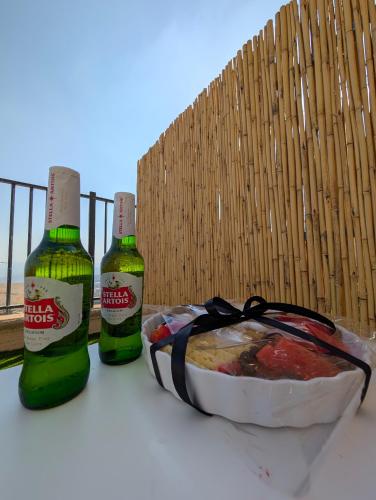 two bottles of beer sitting next to a bowl of food at יחידות נופש מצפה ימים צפת in Safed
