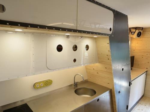 eine Küche mit einem Waschbecken und zwei Löchern in der Wand in der Unterkunft SnowSun -Vacances Pirinenca in Incles