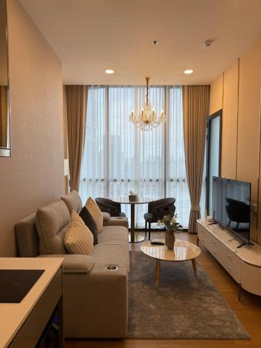 a living room with a couch and a tv at Luxury 1 bedroom near Siam Paragon in Bangkok