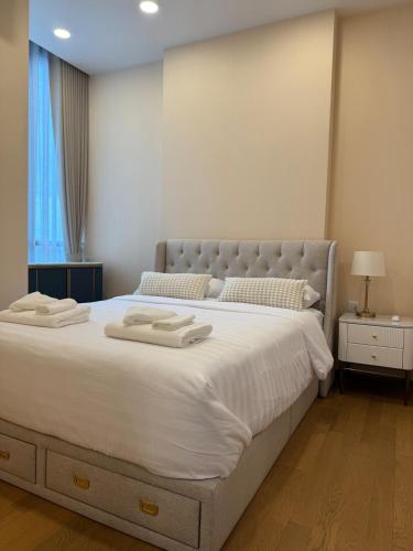 a bedroom with a large white bed with two towels on it at Luxury 1 bedroom near Siam Paragon in Bangkok