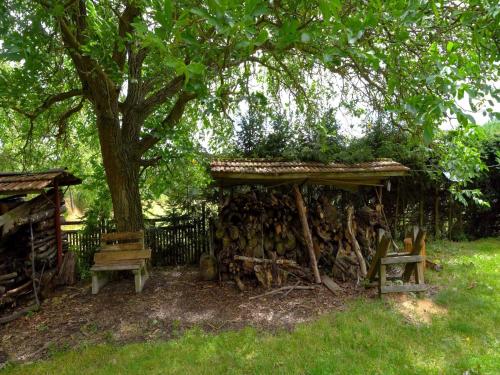 a wooden shelter with benches under a tree at Outdoor Adventure & Relaxation in Svinařov