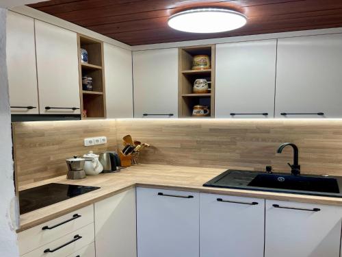 a kitchen with white cabinets and a sink at Outdoor Adventure & Relaxation in Svinařov