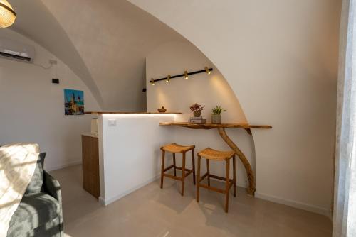 a kitchen with a counter and two stools at Zaroob Guest House in ‘Akko