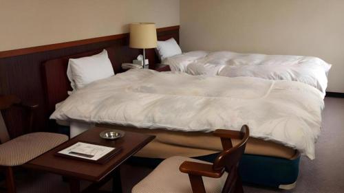 a hotel room with a bed and a table with a chair at AKISAWA HOTEL in Shimanto