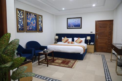 a hotel room with a bed and a blue chair at Nizalia Hotel by Marvelous Holidays in Patriata