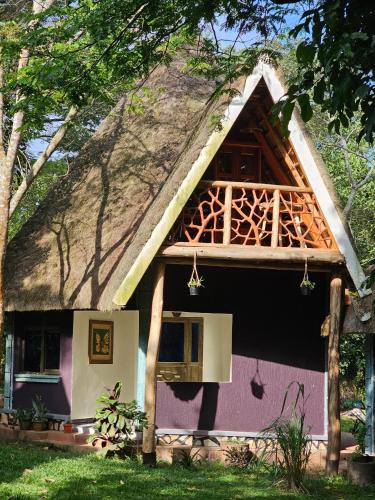 una pequeña casa con techo de paja en Nguru Farm, en Wakiso