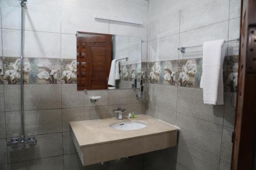 a bathroom with a sink and a mirror at Nizalia Hotel by Marvelous Holidays in Patriata