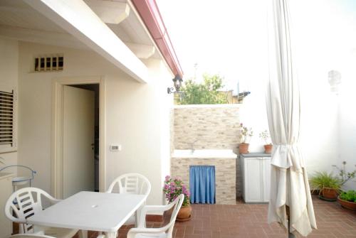 Biały stół i krzesła na patio w obiekcie Casa Dei Furnari w mieście Collepasso