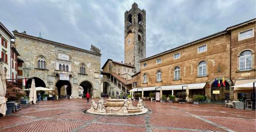 a town square with a clock tower and a fountain at Casa vacanze Clorofilla in Bergamo