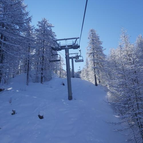a ski lift on a snow covered ski slope at Chalet ALLEMAND in Sauze dʼOulx