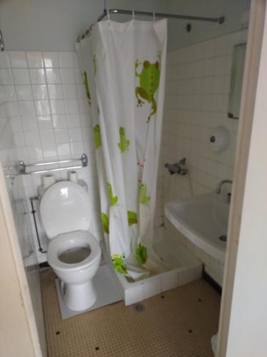 a bathroom with a toilet and a sink and a tub at Hotel Pinede in Saint-Jean-de-Monts