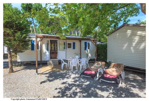 a small white house with a table and chairs at Vic's Land Holidays in Grimaud