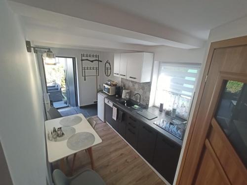 eine kleine Küche mit einer Theke und einem Tisch in der Unterkunft Apartament pod lipami in Jedlina-Zdrój