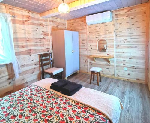 una camera con letto, frigorifero e sedia di Siedlisko przy lesie Musiejówka 