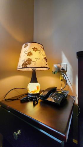 a lamp sitting on top of a desk with a keyboard at Golden Castle Hotel Hoima in Hoima