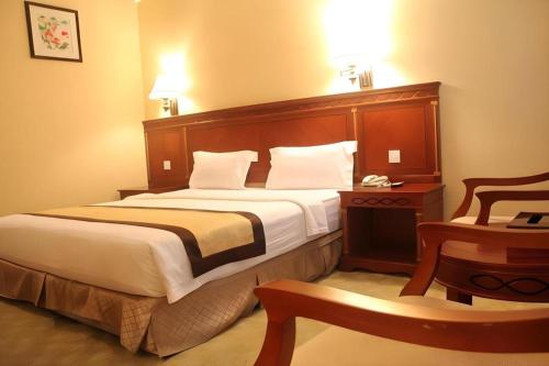 a hotel room with a large bed and a table at MB Hotel in Tawau