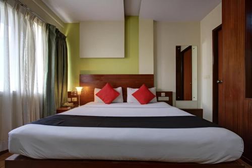 にあるStay Retreats At Hotel Destiny Nagpur - Near Airportのベッドルーム1室(大型ベッド1台、赤い枕付)
