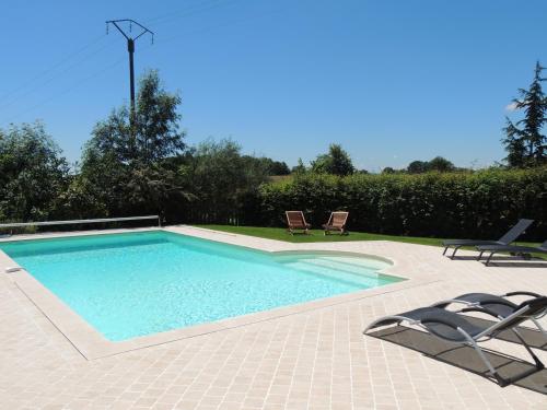 - une piscine avec 2 chaises longues et 2 chaises dans l'établissement chambres d'hôtes le Boyer, à Mantenay-Montlin