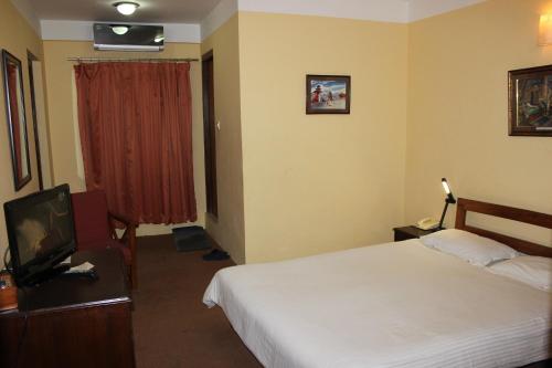 a hotel room with a bed and a television at Royal Astoria Hotel in Kathmandu