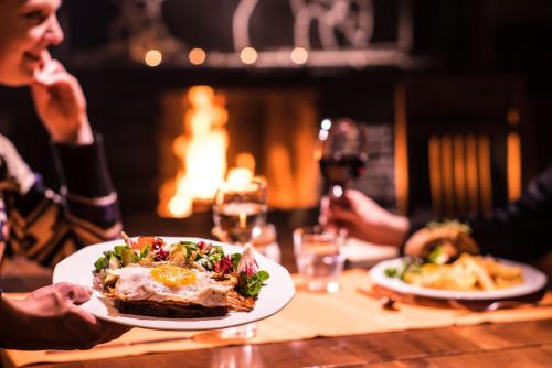 a group of people sitting at a table with a plate of food at Tundrea Holiday Resort in Kilpisjärvi