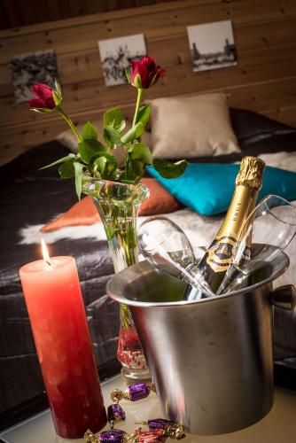 a candle and a vase with a bottle of champagne at Tundrea Holiday Resort in Kilpisjärvi