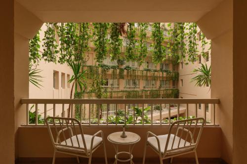 a balcony with two chairs and a building at Iberotel Luxor in Luxor