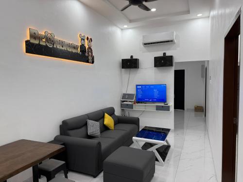 a living room with a couch and a television at 吉胆岛玖壹壹民宿 in Bagan Teochew