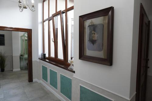 a hallway with windows and a picture on the wall at Sibla Residence, Unique Experience Heritage House in Lugoj