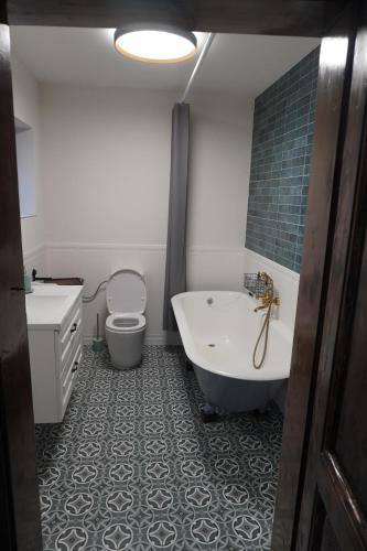 a bathroom with a tub and a toilet and a sink at Sibla Residence, Unique Experience Heritage House in Lugoj
