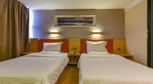 a hotel room with two beds and a window at 7 Days Premium Zhuhai Gongbei Light Railway Branch in Zhuhai