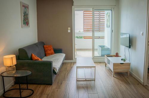 a living room with a couch and a table at Bel appartement vue mer - Mafat'appart in La Possession