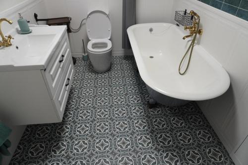 a bathroom with a toilet and a sink and a tub at Sibla Residence, Unique Experience Heritage House in Lugoj