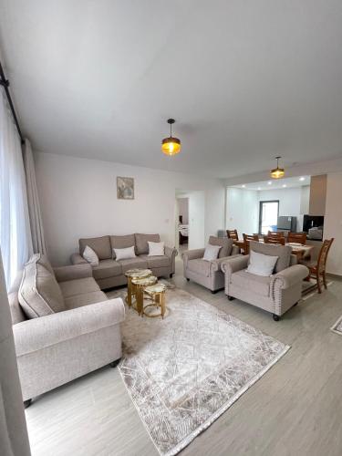 a large living room with couches and a table at Furnished 2-Bedroom Apartment with Swimming pool, Gym and Sauna in Gatunga