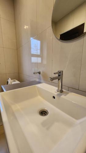 a bathroom with a white sink and a mirror at Golden Castle Hotel Hoima in Hoima