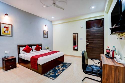 a bedroom with a bed and a desk and a television at Maayra Inn in Noida