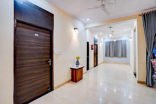 a hallway with a wooden door in a house at Maayra Inn in Noida
