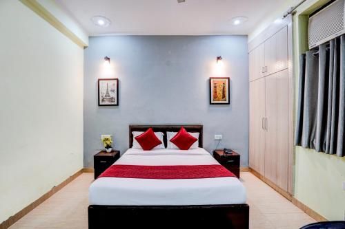 a bedroom with a large bed with red pillows at Maayra Inn in Noida