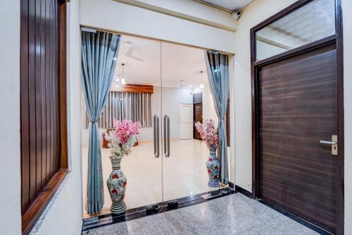 two vases with flowers in them in a hallway at Maayra Inn in Noida