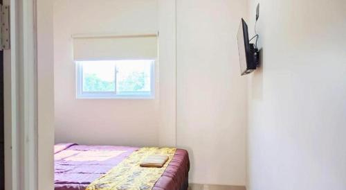 a small bedroom with a bed and a window at Baltis Inn 3 Banyumanik in Semarang