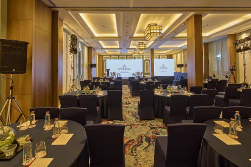 a conference room with tables and chairs and a screen at ICONIQA Hotel Mumbai International Airport in Mumbai