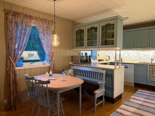 cocina con mesa, sillas y mesa en Senja Villa - Hot tub and northern lights view, 