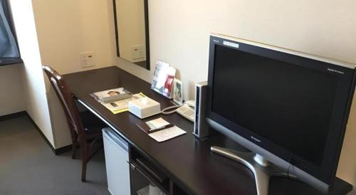 a desk with a large screen television on it at Hotel Gran View Okinawa in Naha